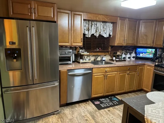 a kitchen with stainless steel appliances a refrigerator sink and cabinets
