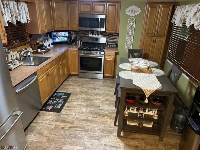 a kitchen with stainless steel appliances granite countertop a stove top oven a sink and cabinets