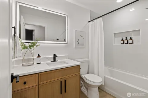 a bathroom with a granite countertop sink toilet and shower