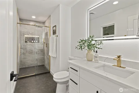 a bathroom with a sink a toilet and shower