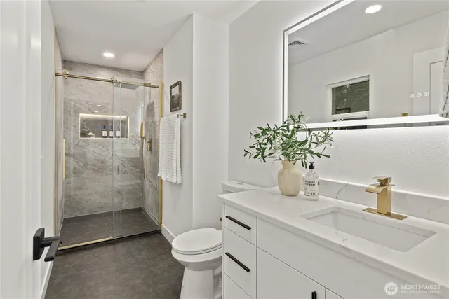 a bathroom with a sink a toilet and shower