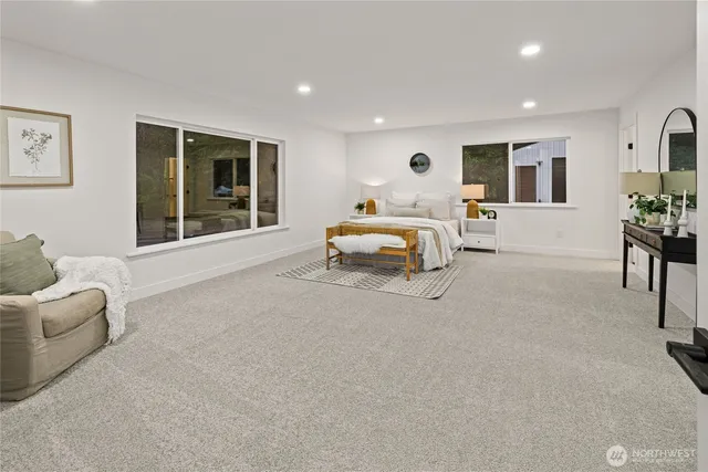 a bedroom with furniture and a large window