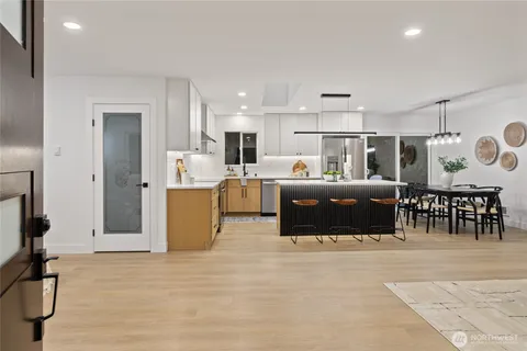 a living room with stainless steel appliances kitchen island granite countertop a cabinets and a view of living room