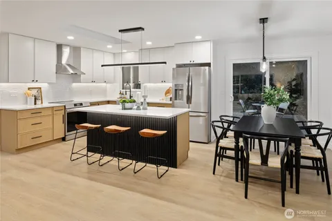 a kitchen with kitchen island a dining table and chairs