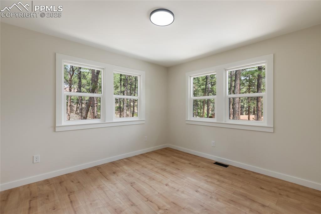 1320 Spring Valley Drive Colorado Springs, CO 80921 - Photo 26 of 46 a view of an empty room with a window and wooden floor