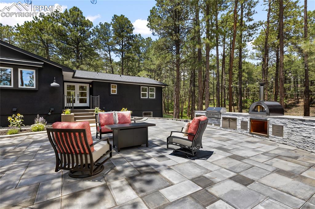 1320 Spring Valley Drive Colorado Springs, CO 80921 - Photo 5 of 46 a backyard of a house with barbeque oven and outdoor seating