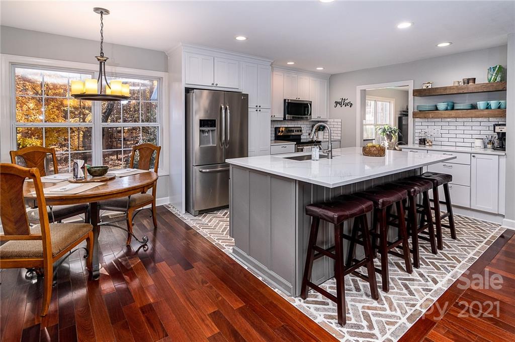 254 Beaten Path Road Mooresville, NC 28117 - Photo 9 of 35 a kitchen with stainless steel appliances a dining table chairs stove refrigerator and cabinets