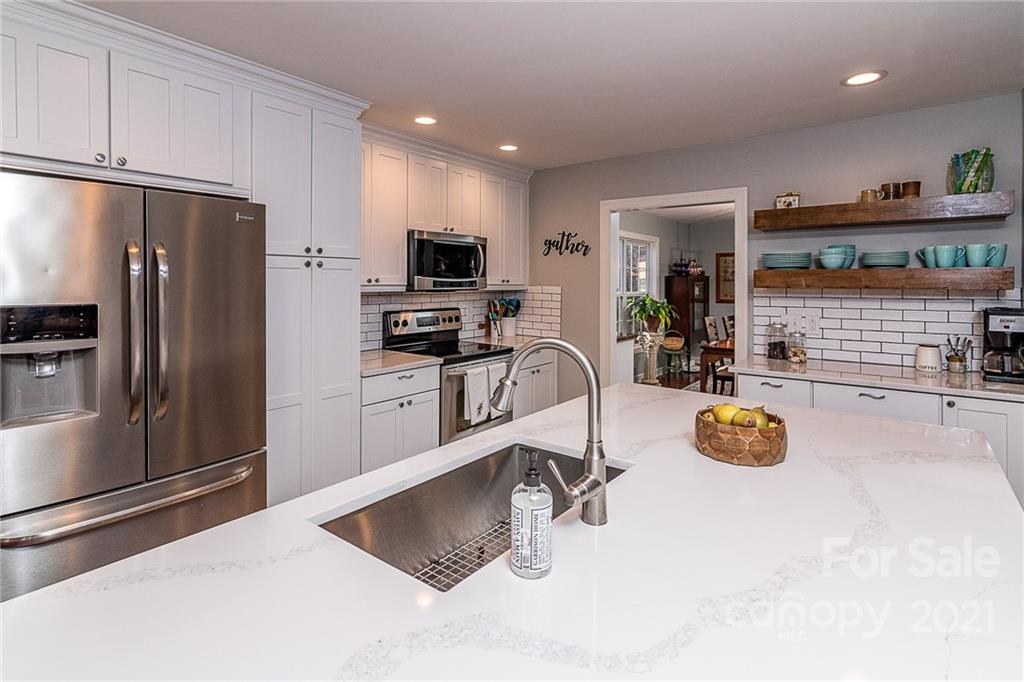 254 Beaten Path Road Mooresville, NC 28117 - Photo 10 of 35 a kitchen with stainless steel appliances a refrigerator a sink a stove and white cabinets