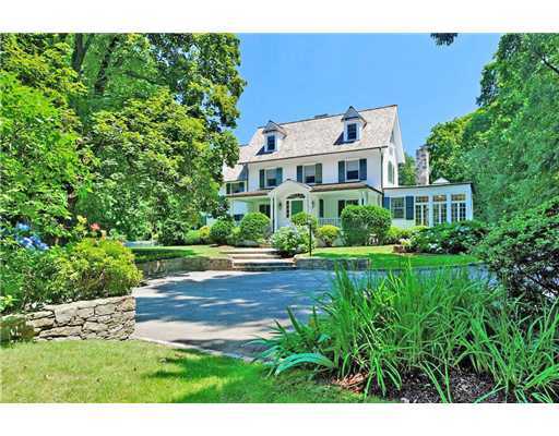a view of a house with a big yard plants and large trees