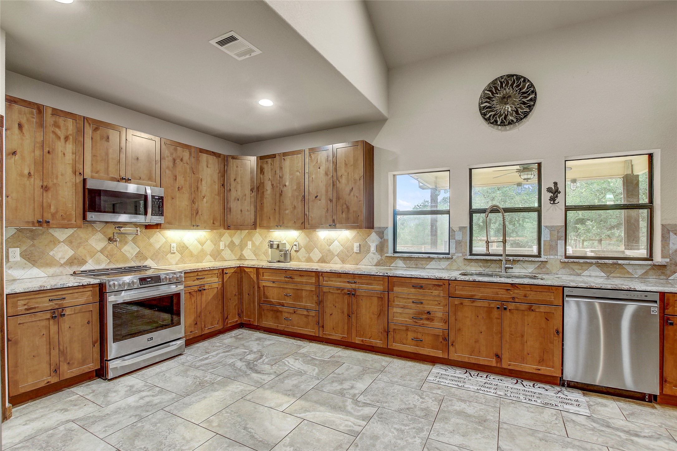 18197 Fm 619 Elgin, TX 78621 - Photo 11 of 39 a large kitchen with stainless steel appliances granite countertop a stove top oven a sink dishwasher and cabinets with wooden floor