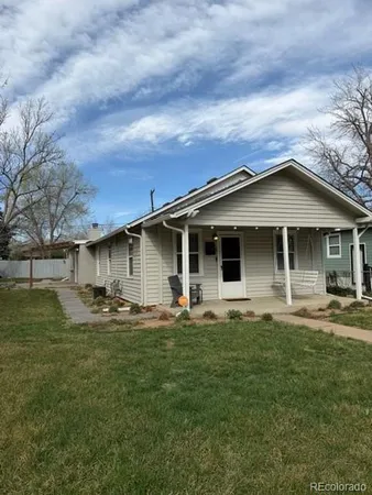 a front view of a house with yard and trees