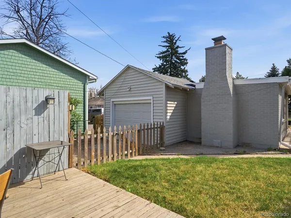 a view of a house with a small yard and wooden fence