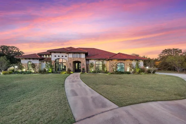 a view of a big house with a big yard and a large trees
