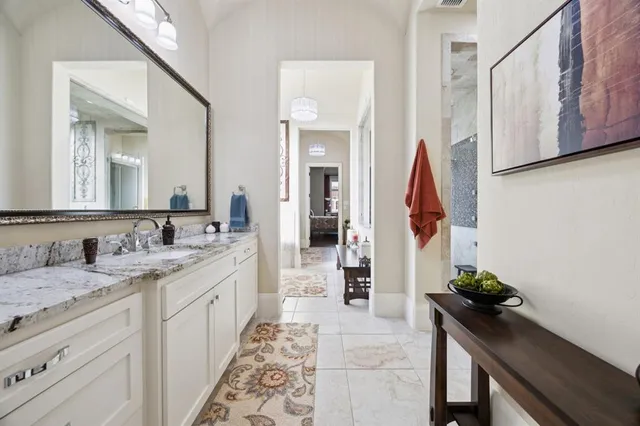 a spacious bathroom with a granite countertop sink and a mirror