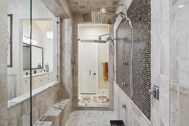 a bathroom with a glass shower door a bathtub and a shower