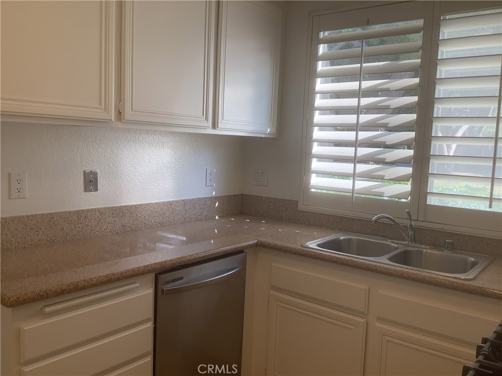 186 Monroe Irvine, CA 92620 - Photo 4 of 12 a kitchen with granite countertop a sink and a white wooden cabinets