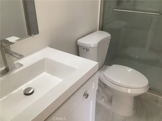 a white toilet sitting next to a bathroom sink