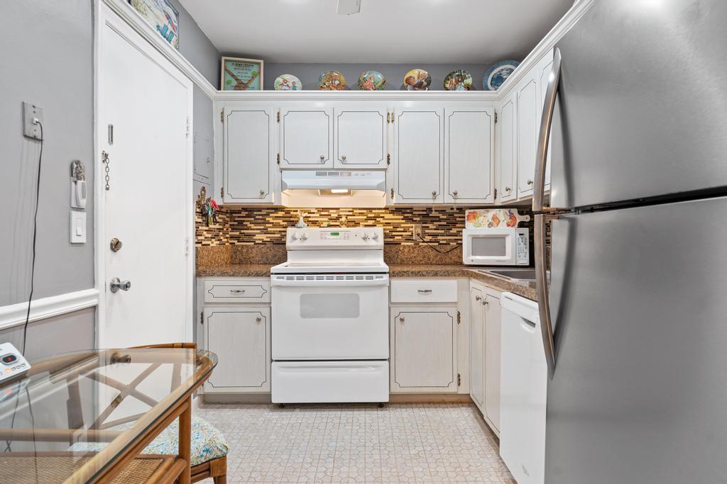 400 South Cypress Road, Unit 424 Pompano Beach, FL 33060 - Photo 16 of 40 a kitchen with white cabinets and white appliances
