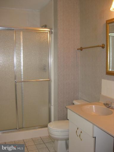 7375 Kindler Road Columbia, MD 21046 - Photo 17 of 27 a bathroom with a granite countertop sink toilet and shower