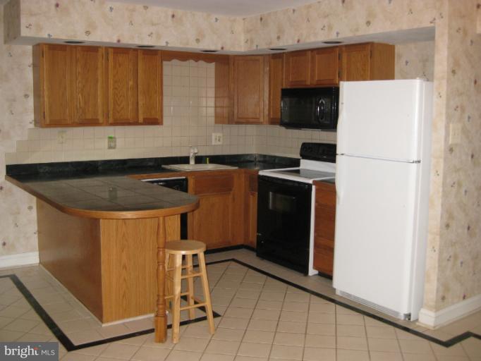 7375 Kindler Road Columbia, MD 21046 - Photo 5 of 27 a kitchen with stainless steel appliances granite countertop a sink stove and refrigerator