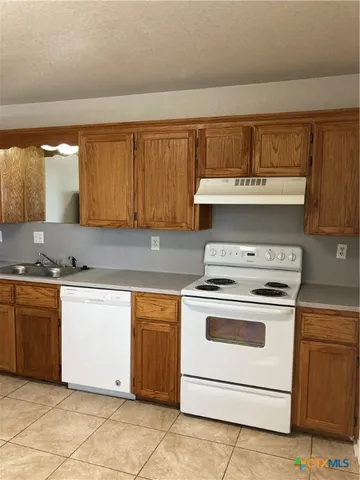 a kitchen with a stove top oven sink and cabinets