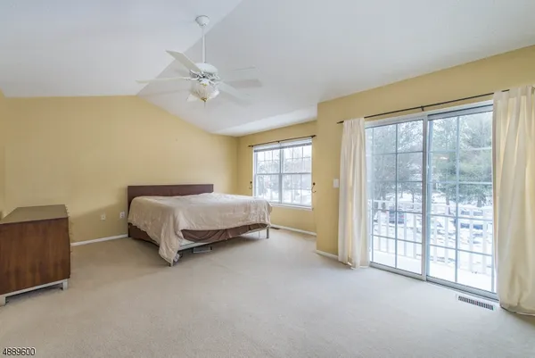 a spacious bedroom with a bed and wooden floor