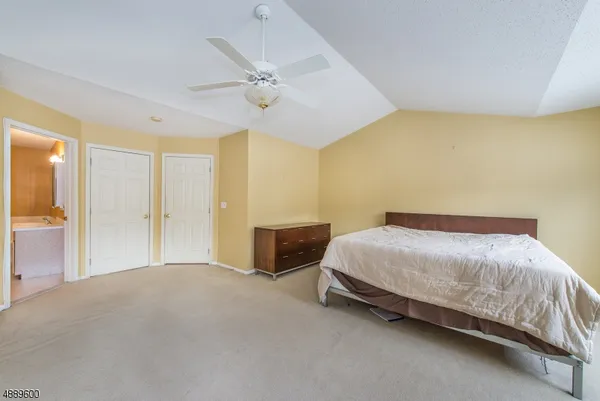 a spacious bedroom with a bed and a chandelier