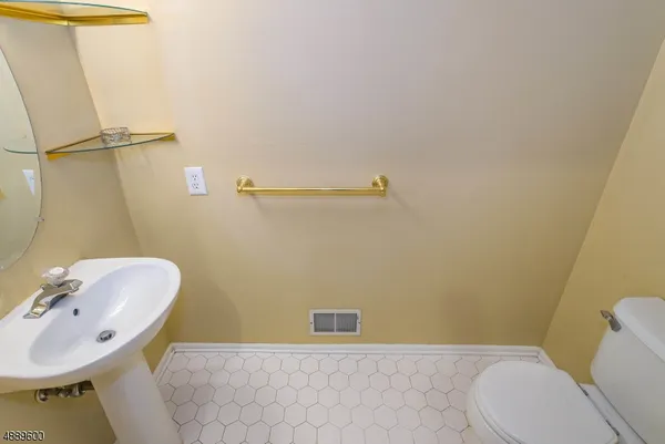 a bathroom with a sink a toilet and a mirror
