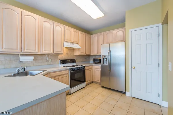 a kitchen with stainless steel appliances granite countertop a refrigerator sink and stove