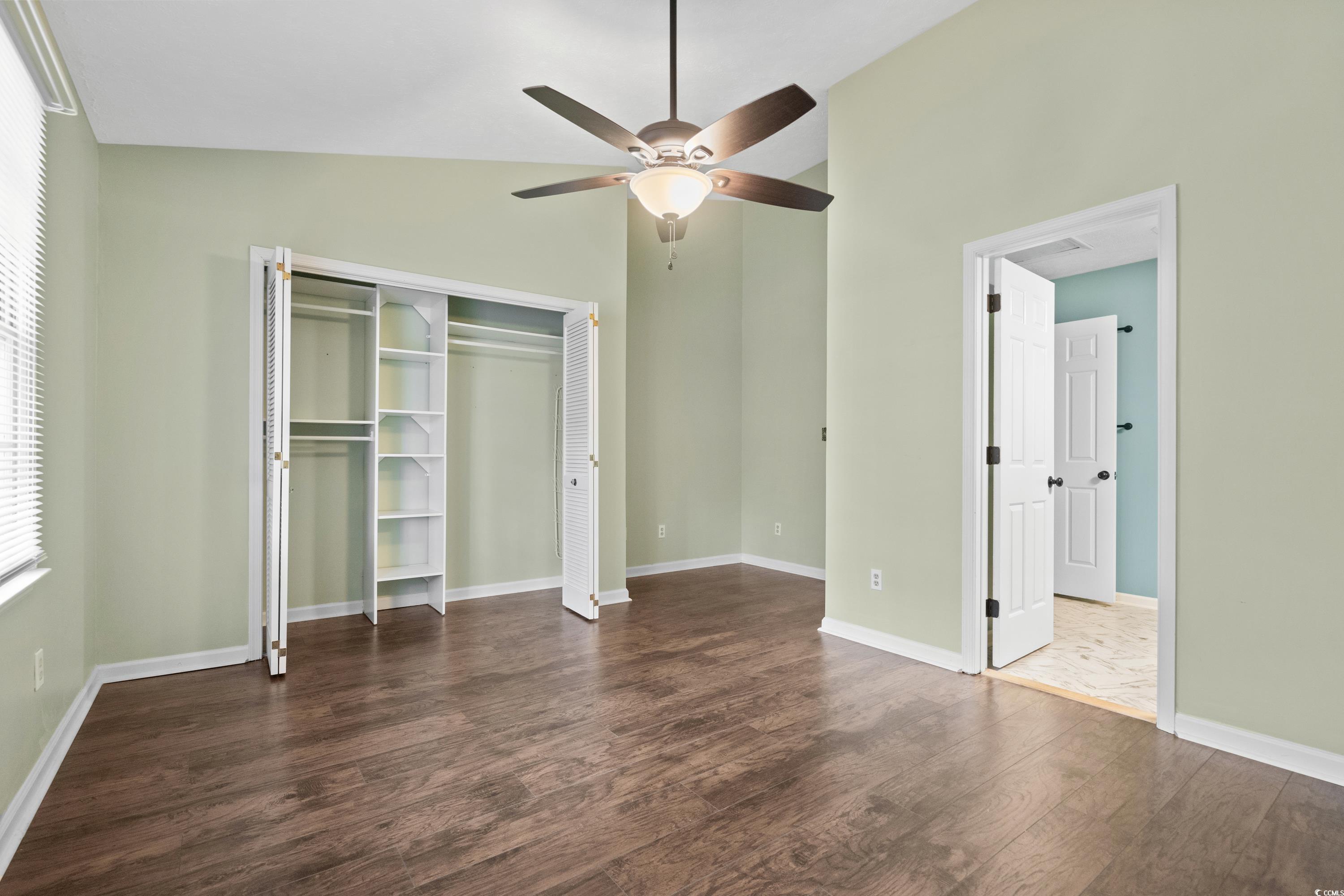 830 44th Avenue North, Unit X5 Myrtle Beach, SC 29577 - Photo 15 of 40 Unfurnished bedroom featuring a closet, ceiling fan, dark hardwood / wood-style flooring, and vaulted ceiling