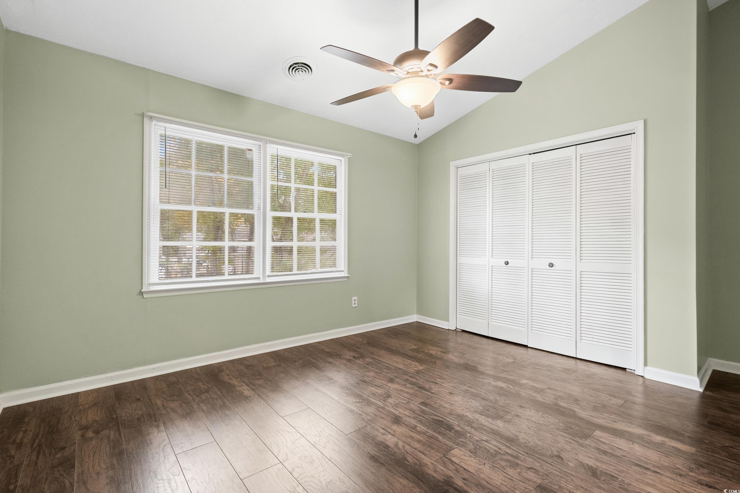 830 44th Avenue North, Unit X5 Myrtle Beach, SC 29577 - Photo 16 of 40 Unfurnished bedroom with dark hardwood / wood-style flooring, a closet, vaulted ceiling, and ceiling fan