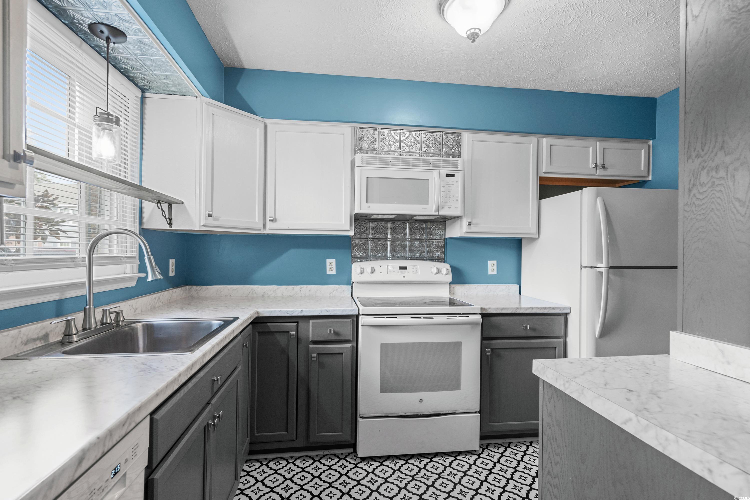 830 44th Avenue North, Unit X5 Myrtle Beach, SC 29577 - Photo 9 of 40 Kitchen featuring pendant lighting, white cabinetry, white appliances, and sink