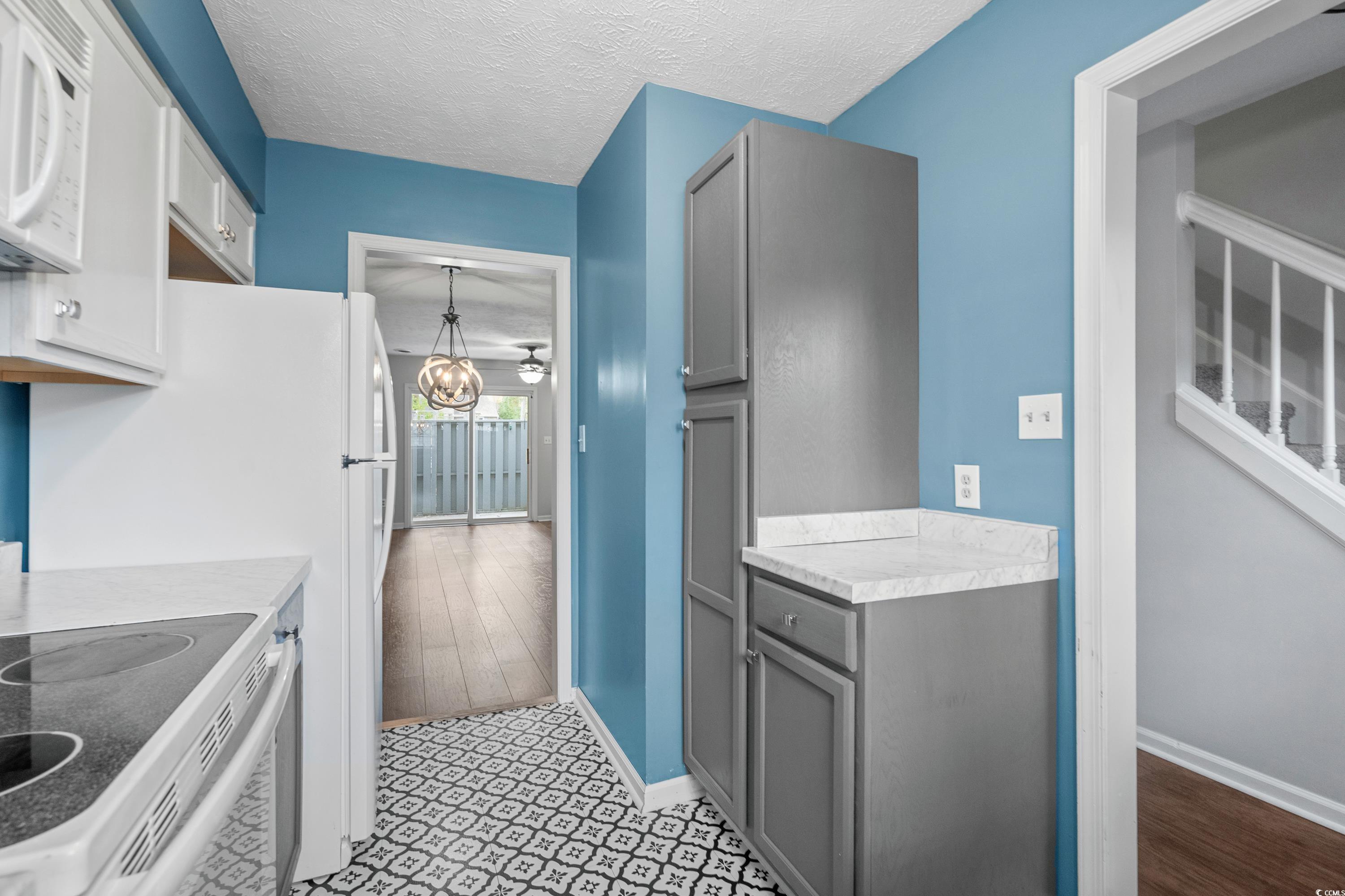 830 44th Avenue North, Unit X5 Myrtle Beach, SC 29577 - Photo 10 of 40 Kitchen with range with electric cooktop, gray cabinetry, a textured ceiling, pendant lighting, and light hardwood / wood-style flooring