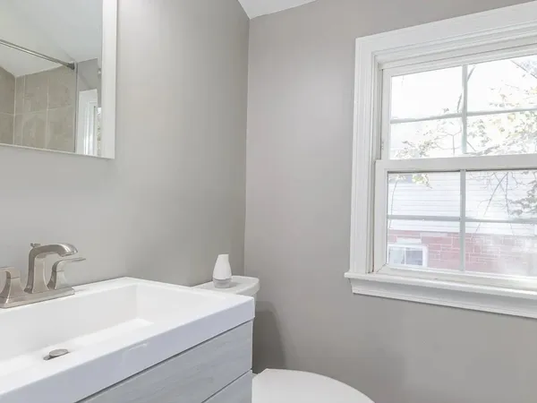 a bathroom with a sink a toilet and a window