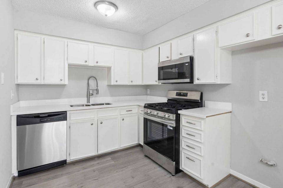 7403 Strawbridge Lane Houston, TX 77040 - Photo 8 of 22 a kitchen with granite countertop white cabinets and stainless steel appliances