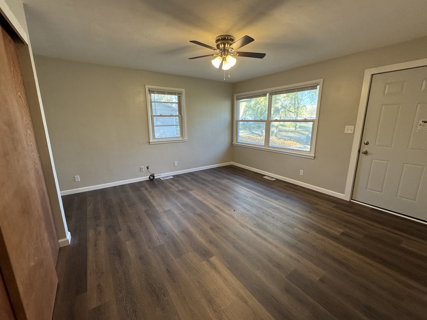 1605 Williamsburg Drive Champaign, IL 61821 - Photo 2 of 11 a view of an empty room with wooden floor and a window