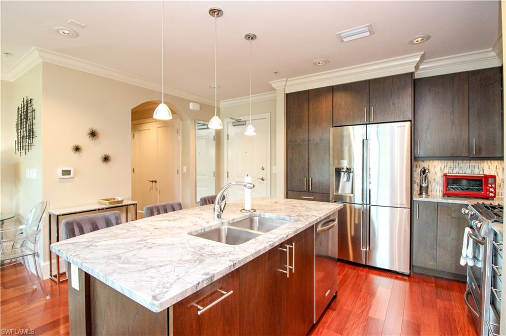 9123 Strada Place, Unit 7410 Naples, FL 34108 - Photo 29 of 50 Kitchen featuring pendant lighting, dark wood-type flooring, stainless steel appliances, and sink