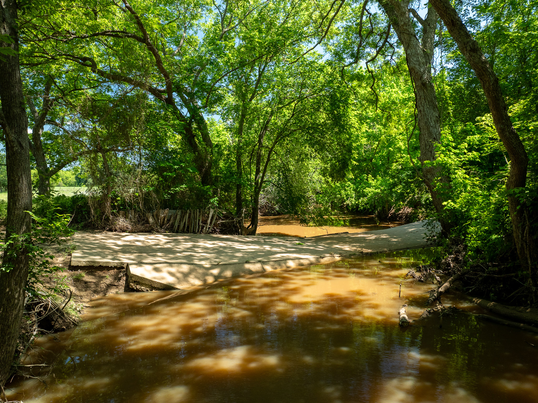 400 619th Spur Elgin, TX 78621 - Photo 20 of 40 A tranquil water crossing with verdant trees lining its banks.