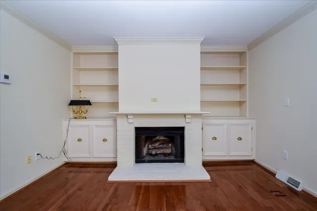 a view of an empty room with a fireplace and a window