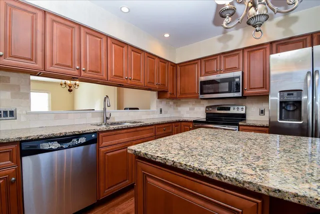a kitchen with stainless steel appliances granite countertop a stove top oven a sink dishwasher and microwave oven
