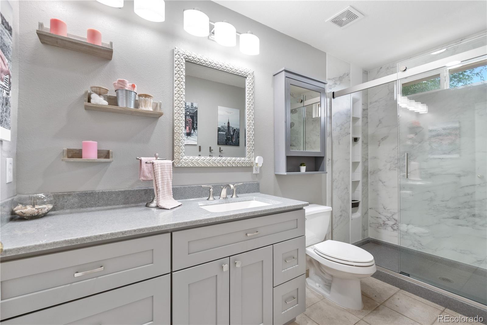 a bathroom with a sink a toilet and shower