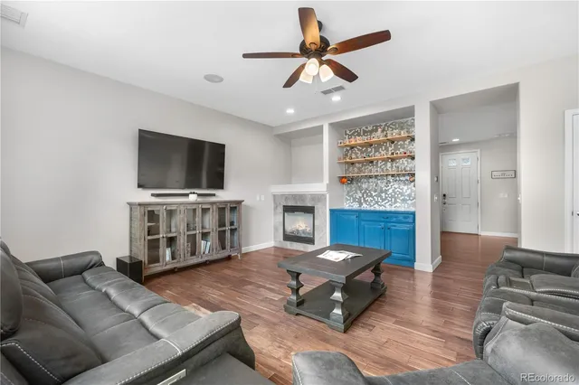 a living room with furniture a flat screen tv and kitchen view