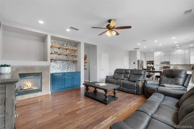 a kitchen with stainless steel appliances granite countertop a stove a refrigerator a kitchen island a table and chairs