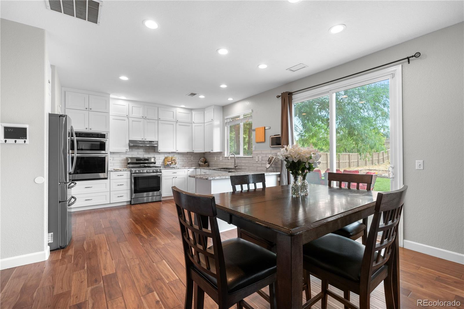 5839 Raleigh Circle Castle Rock, CO 80104 - Photo 18 of 35 a kitchen with stainless steel appliances granite countertop a stove a refrigerator a kitchen island a table and chairs