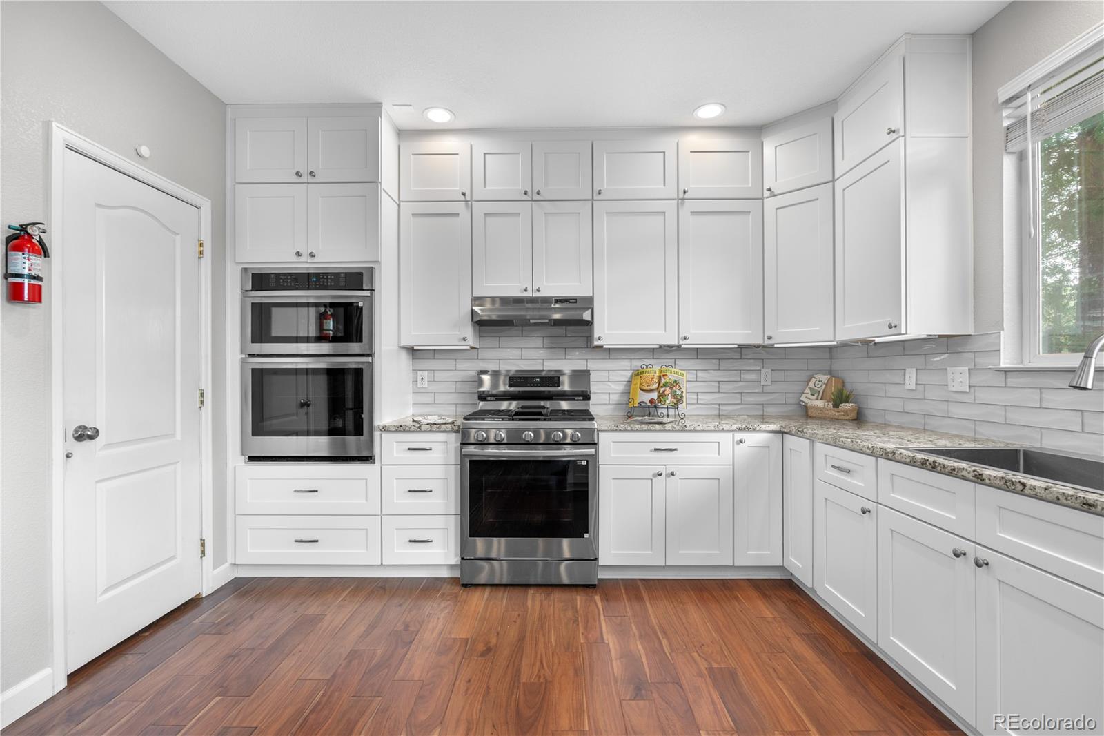 5839 Raleigh Circle Castle Rock, CO 80104 - Photo 19 of 35 a kitchen with cabinets wooden floor and a sink