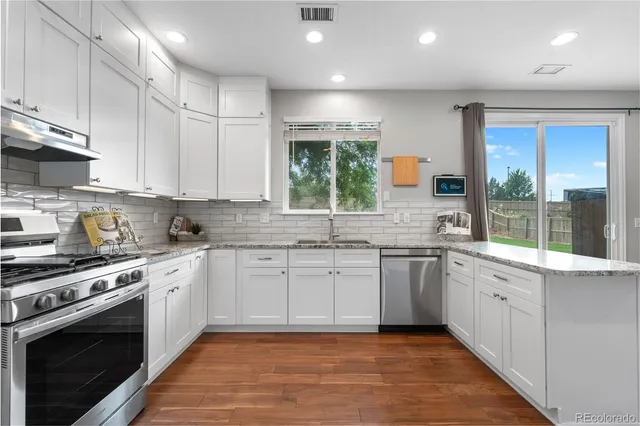 a kitchen with stainless steel appliances granite countertop a stove and a microwave