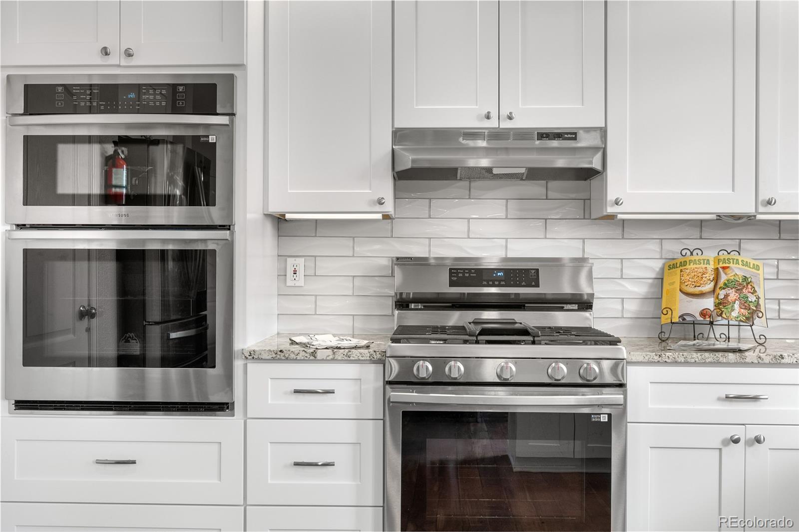 5839 Raleigh Circle Castle Rock, CO 80104 - Photo 22 of 35 a kitchen with stainless steel appliances granite countertop a stove and a microwave
