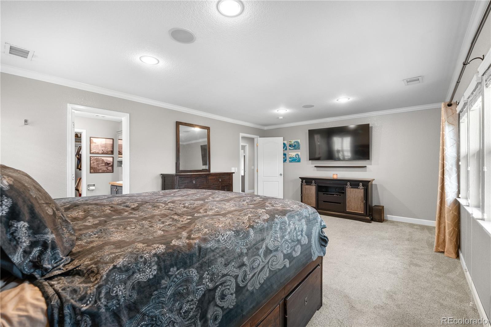 5839 Raleigh Circle Castle Rock, CO 80104 - Photo 29 of 35 a spacious bedroom with a bed and a flat screen television