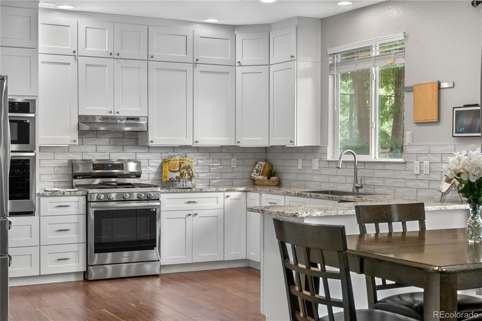 5839 Raleigh Circle Castle Rock, CO 80104 - Photo 4 of 35 a kitchen with stainless steel appliances granite countertop a stove and white cabinets