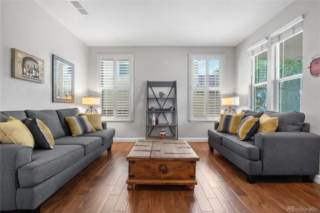 a living room with furniture and a wooden floor